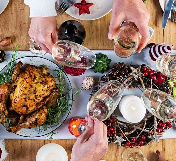 mesa en la cena de navidad y personas brindando con sus copas
